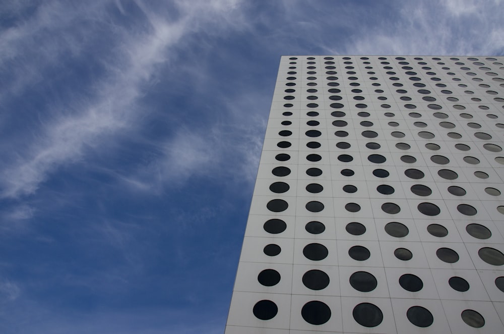 a tall building with a lot of round holes on it