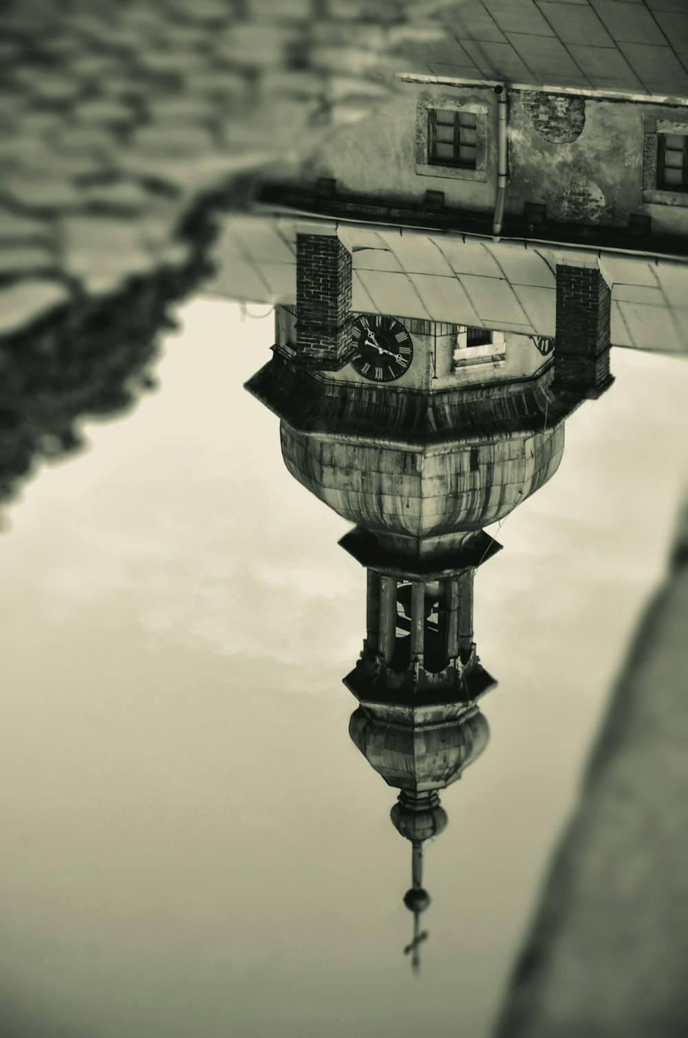 a reflection of a clock tower in the water