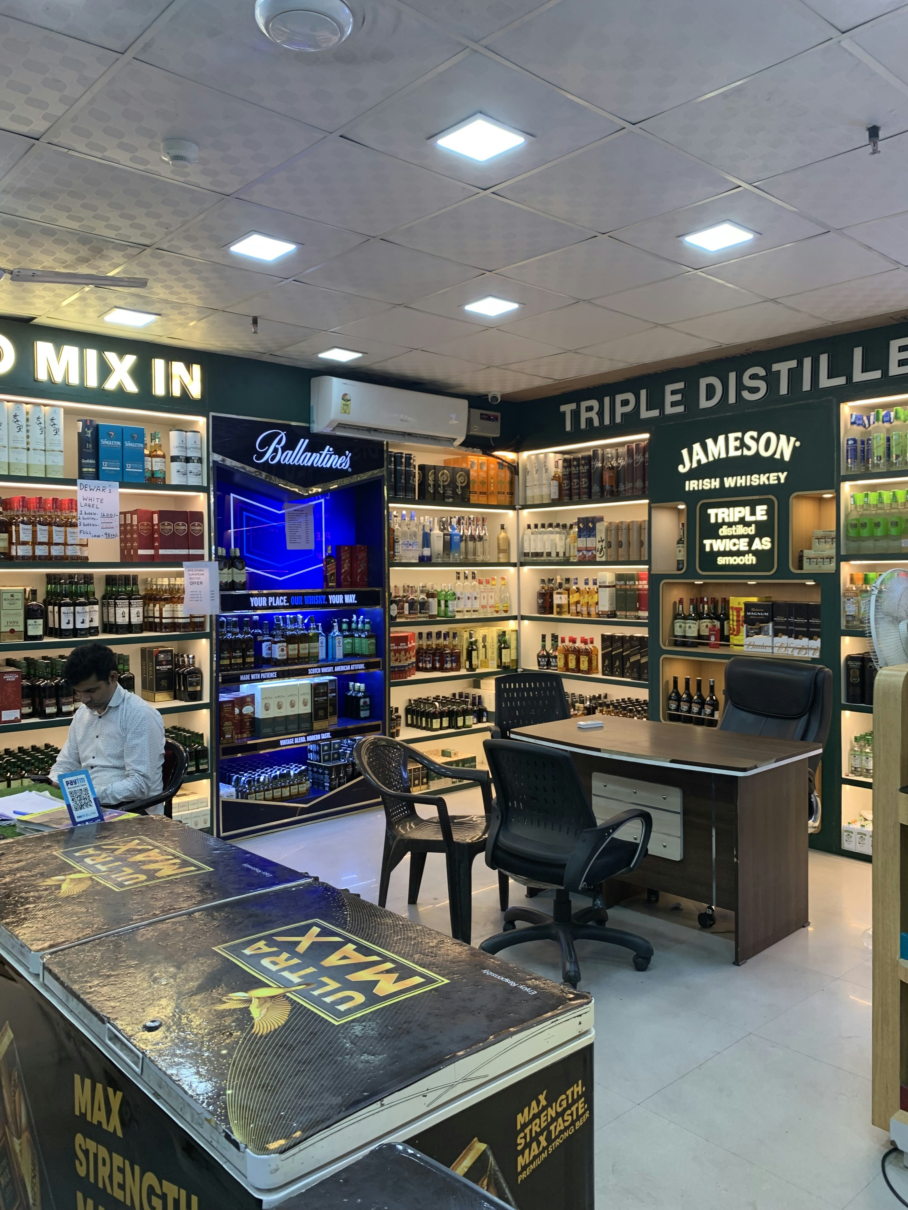 Liquor store owner smiling behind a well-organised counter