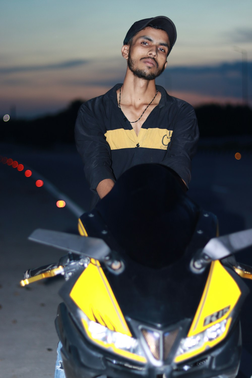 Ein Mann steht neben einem gelb-schwarzen Motorrad