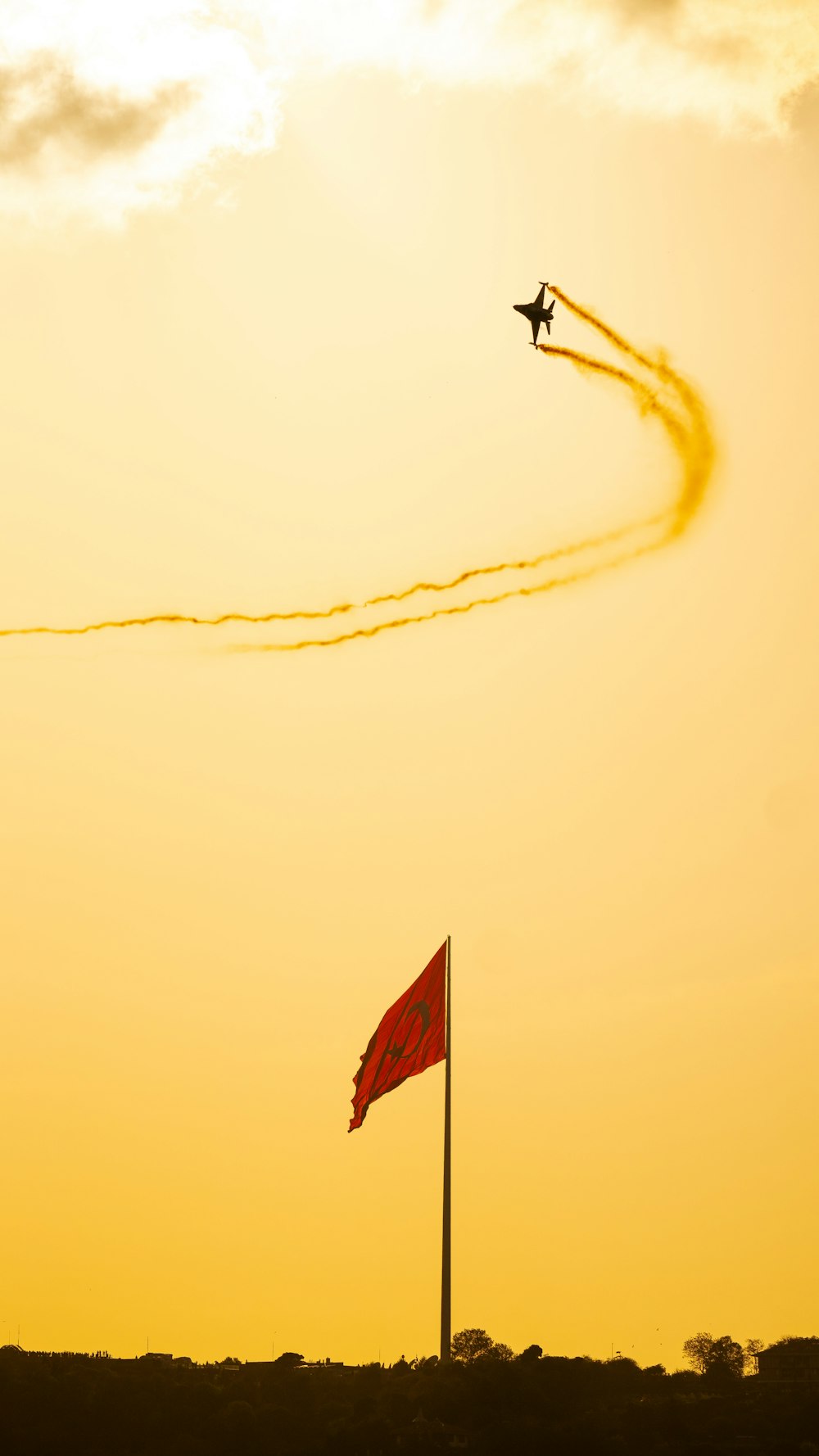 a plane flying in the sky with a red flag