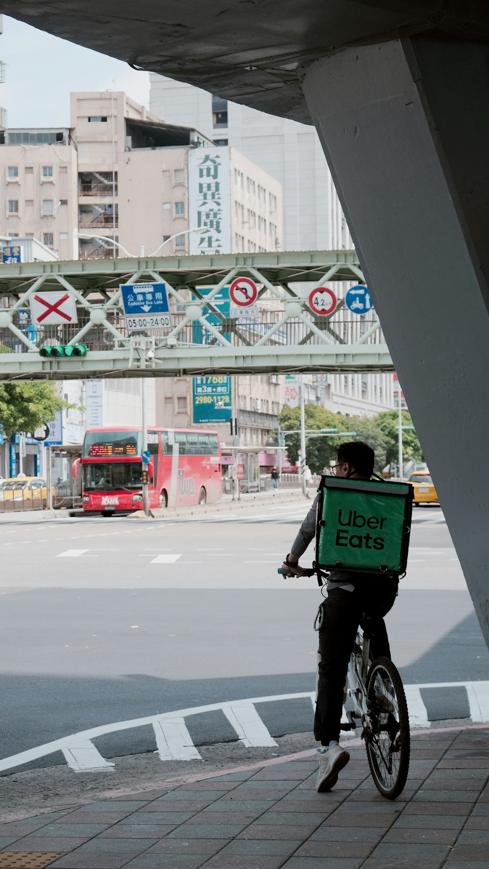 Un homme faisant du vélo dans une rue sous un pont