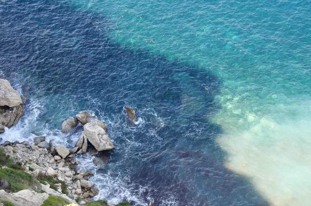 a body of water surrounded by rocks and grass