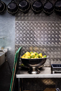 Close-up of a sleek digital kitchen scale with a bowl of fresh ingredients on top.