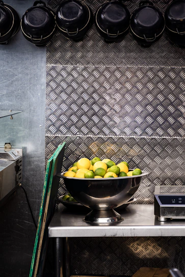 Close-up of a sleek digital kitchen scale with a bowl of fresh ingredients on top.