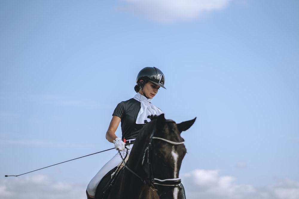 une femme chevauchant le dos d’un cheval brun