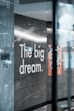 a sign on a glass wall that says the big dream