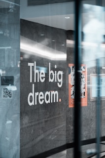 a sign on a glass wall that says the big dream