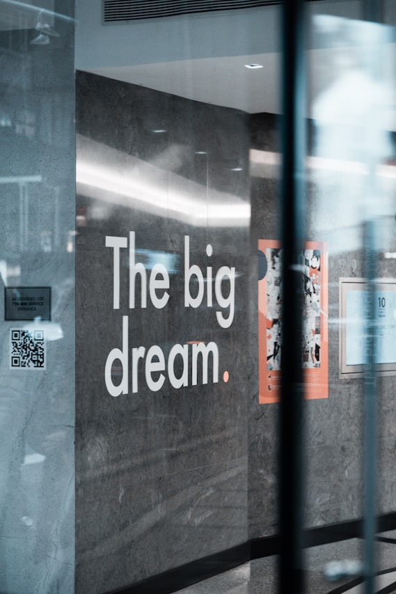 a sign on a glass wall that says the big dream