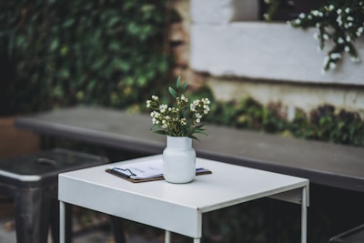 A simple vase with fresh greenery on a clean white countertop.
