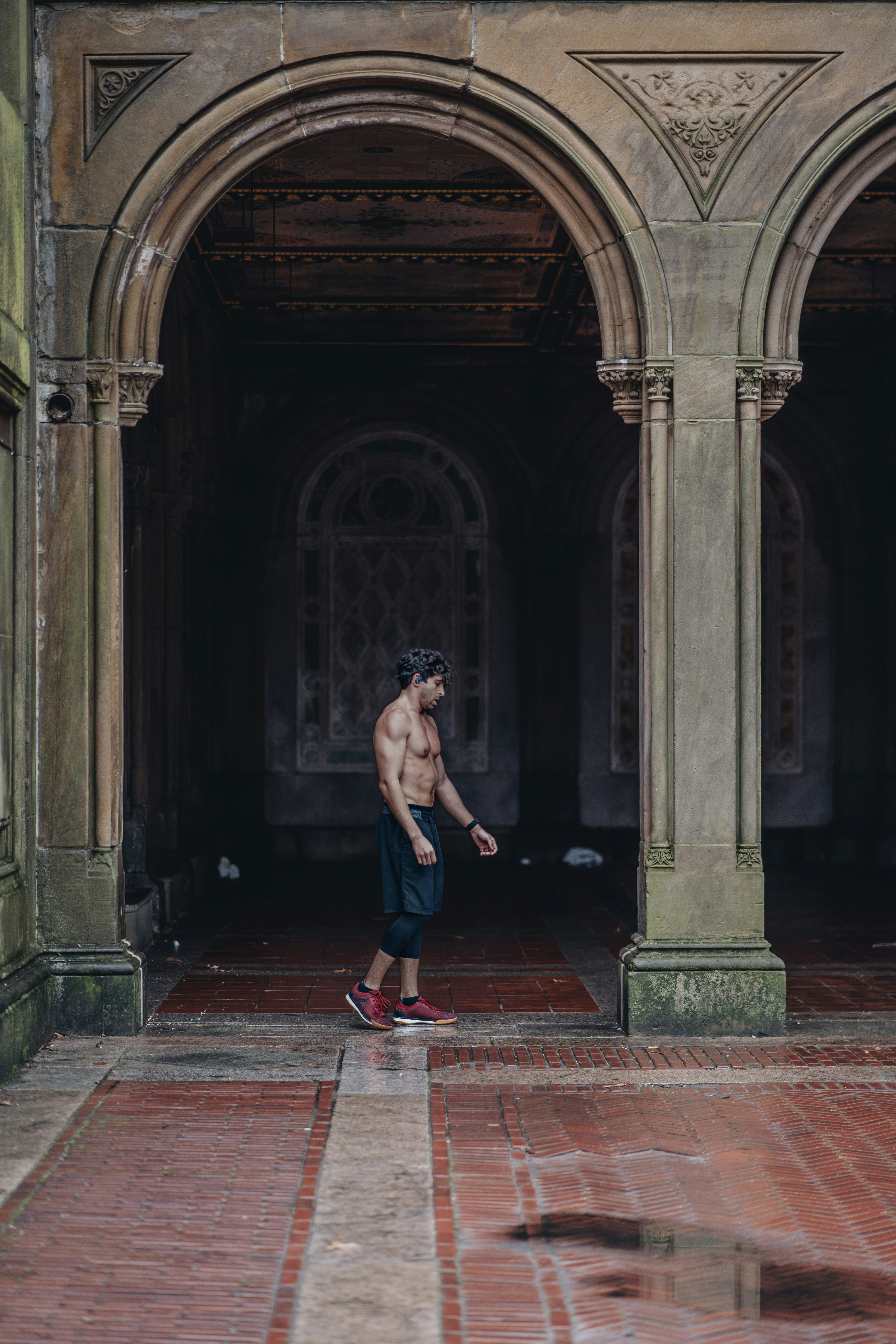 Un hombre sin camisa de pie en un edificio viejo