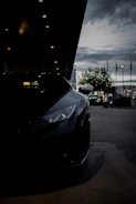 A sleek sports car under city lights, reflecting a premium dark aesthetic.