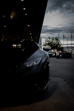 A sleek sports car under city lights, reflecting a premium dark aesthetic.