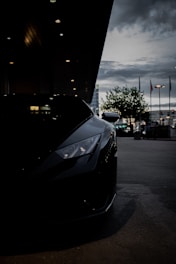 Sporty car with dark, glossy window tints reflecting city lights at dusk.