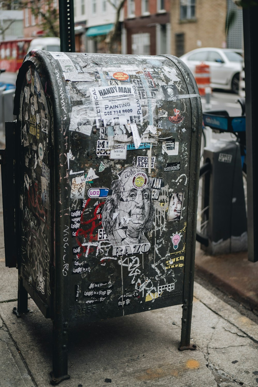 a mailbox covered in graffiti on a city street