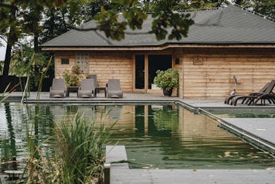A tranquil pool house with natural wood accents and lush surrounding greenery.