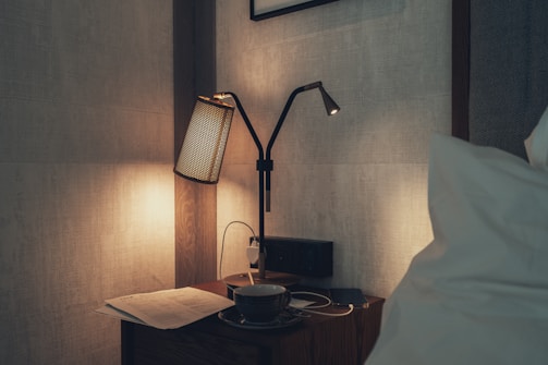 A compact table lamp with a USB port glowing warmly on a bedside table, perfect for late-night reading.