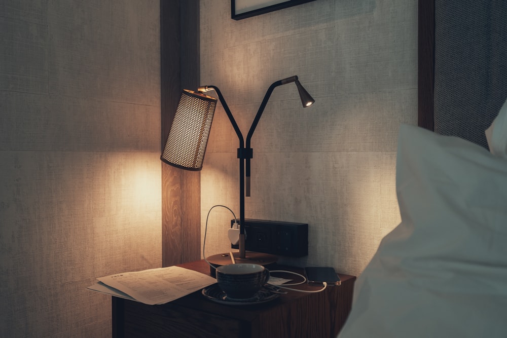 a lamp on a nightstand next to a bed