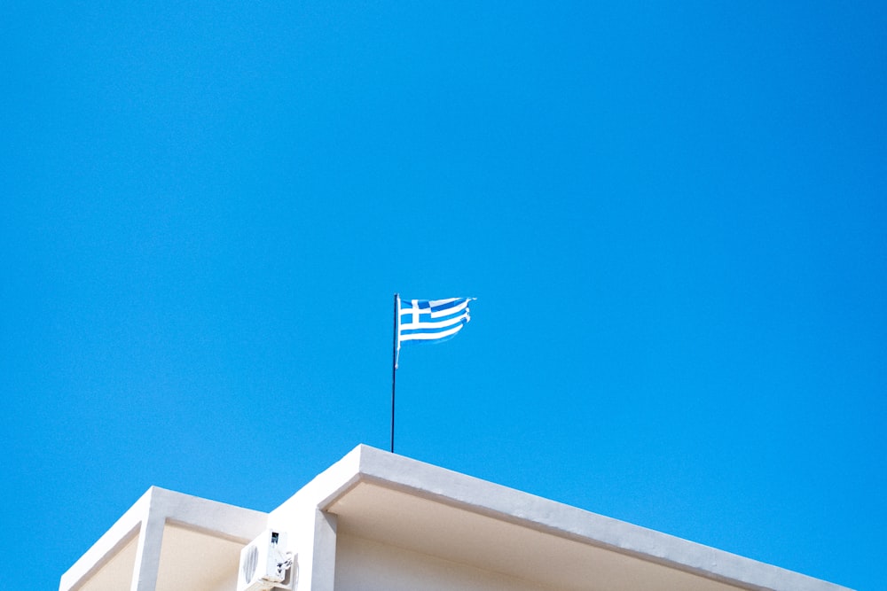 a flag on top of a building with a blue sky in the background