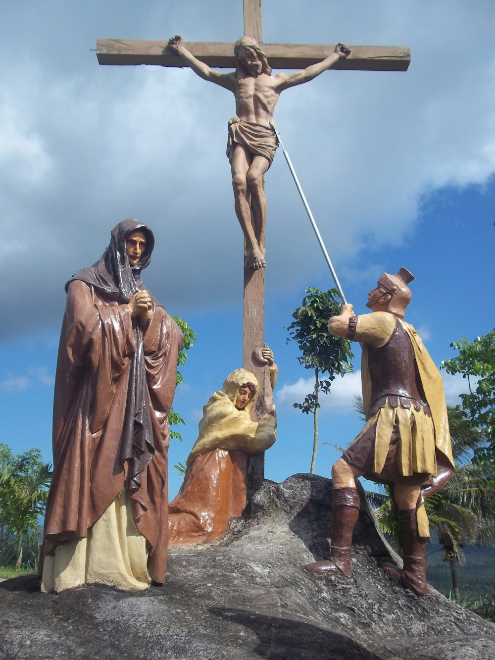 Uma estátua de Jesus na cruz com dois homens