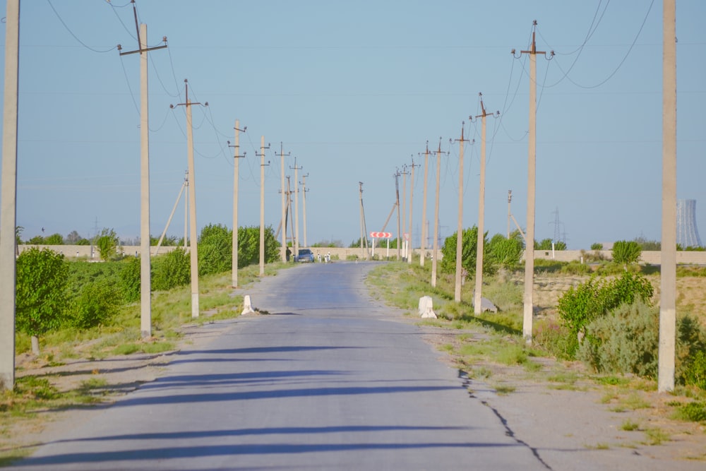 an empty road surrounded by power lines and telephone poles