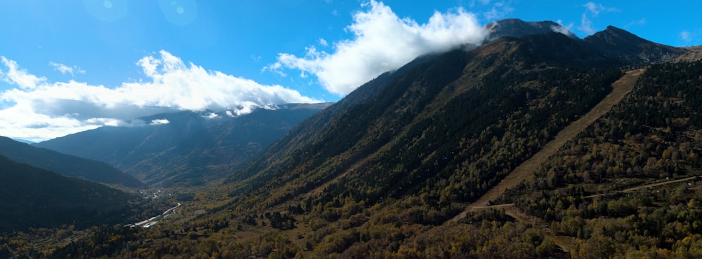 a scenic view of a valley with mountains in the background