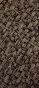 Close-up of woven textile with natural fibers and earthy tones.
