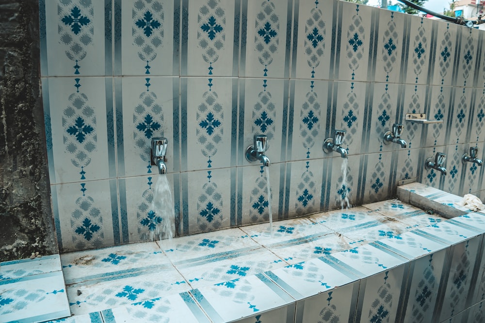 a public bathroom with blue and white tiles