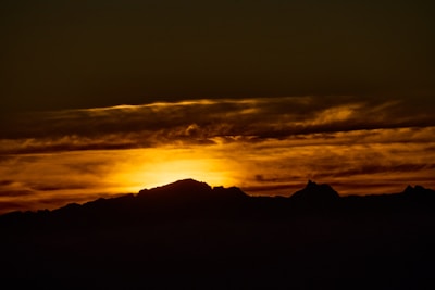 Sunset casting warm light over the rugged puna mountains surrounding Lagunillas del Farallón.