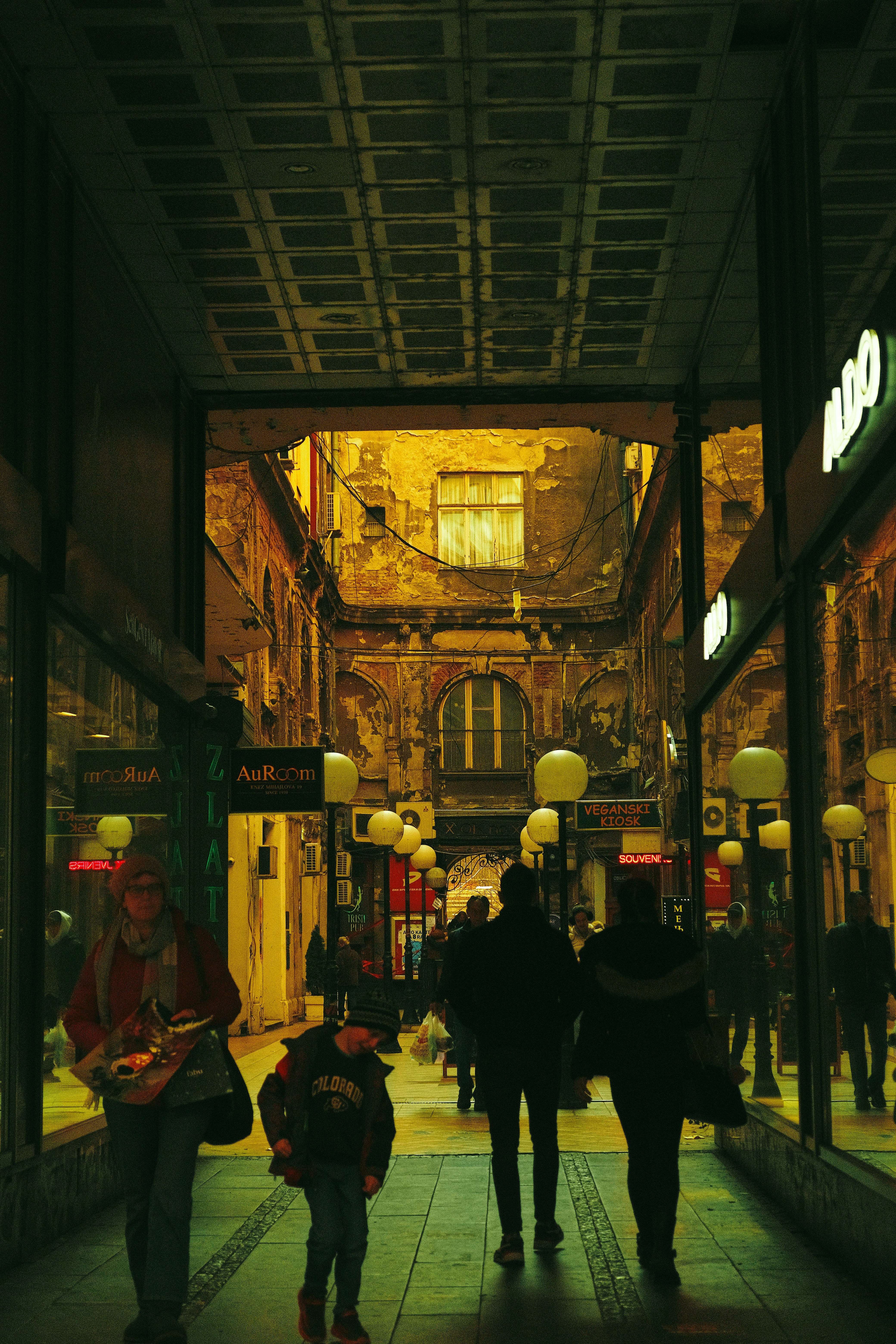 a group of people walking down a street at night