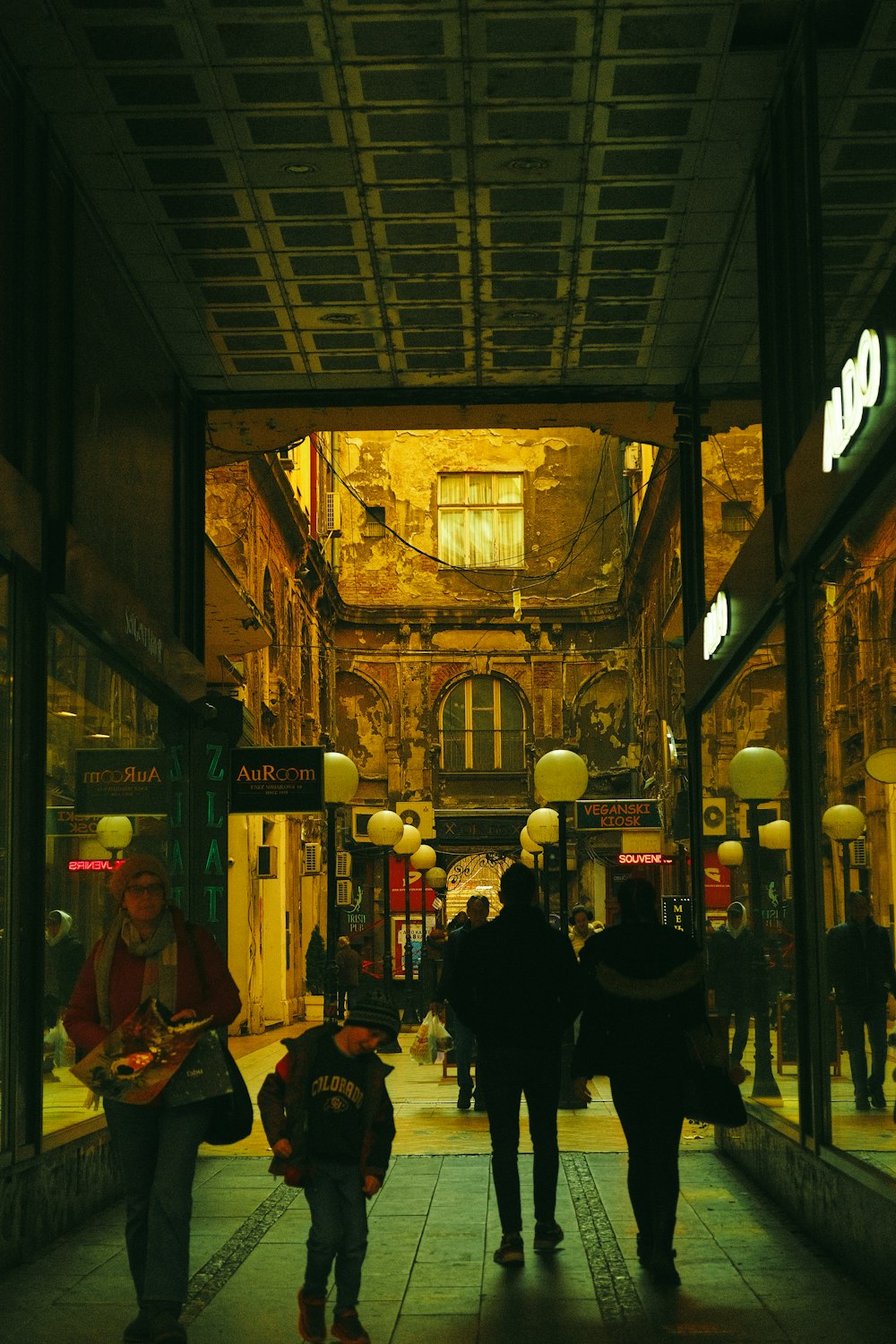 a group of people walking down a street at night