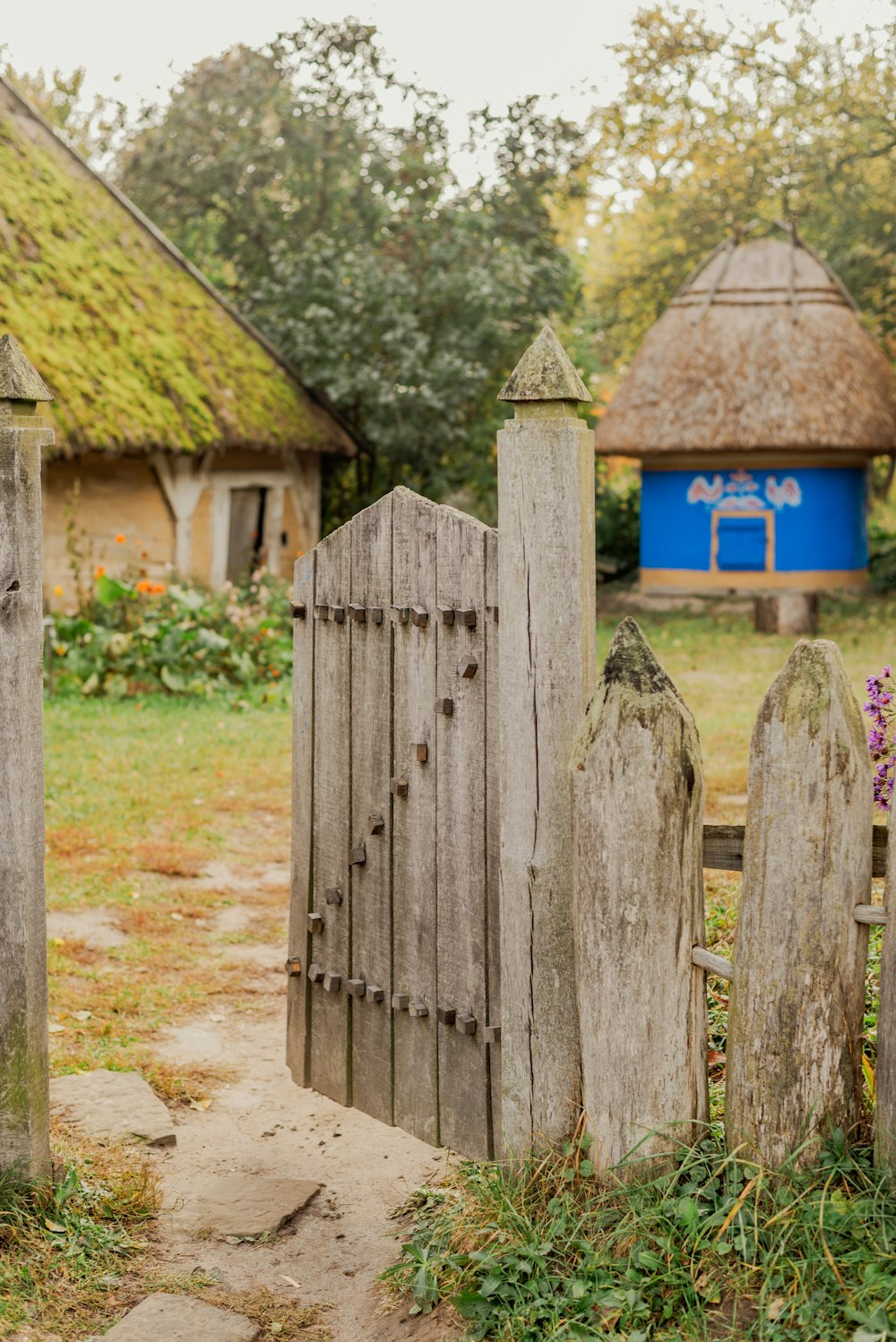 an old wooden gate with a thatched roof