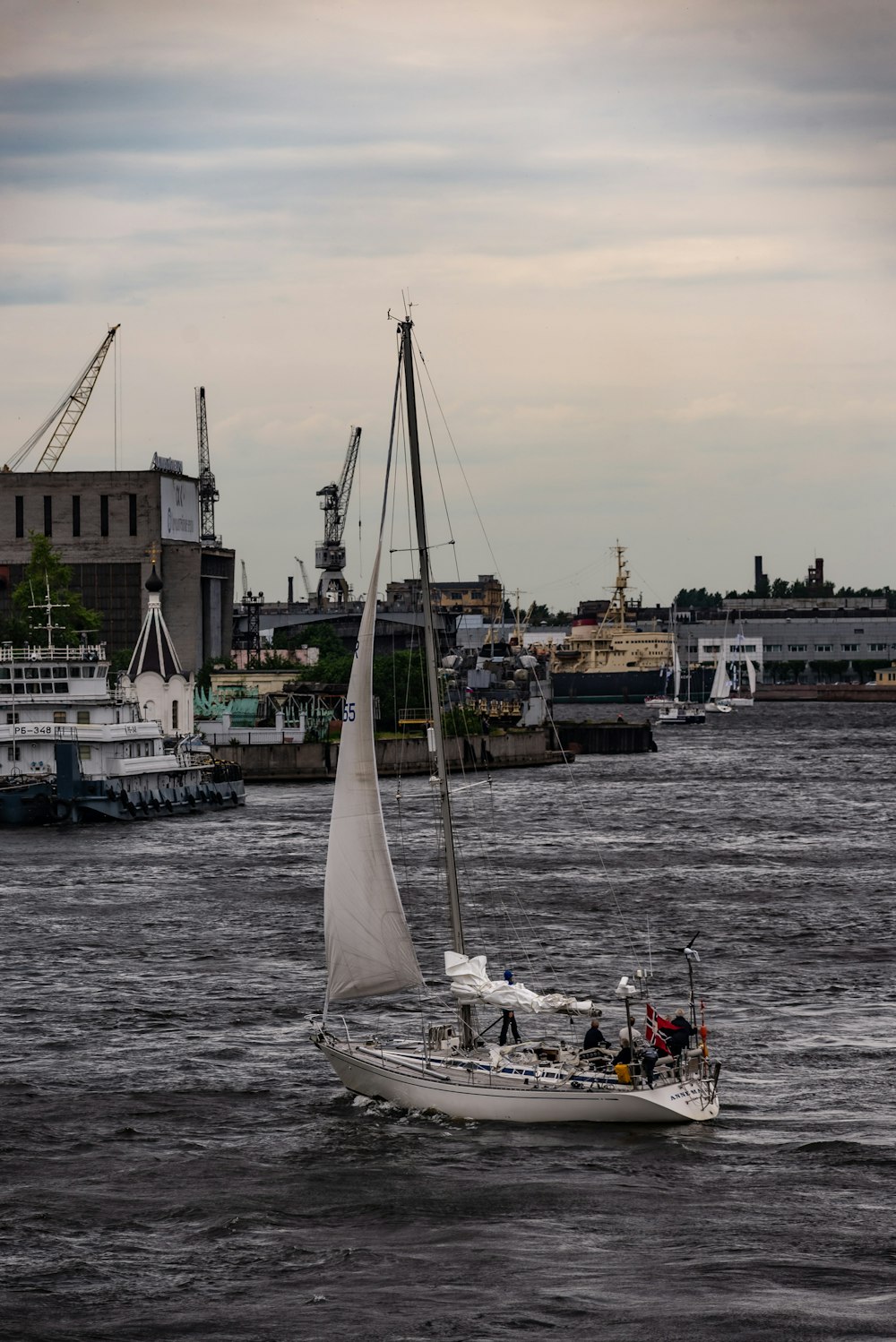 Un velero en un cuerpo de agua con una ciudad al fondo