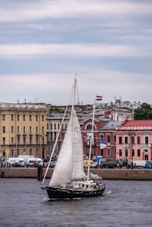 Sailboat gliding smoothly on the Tagus River with Lisbon’s historic skyline in the background under a golden sunset.