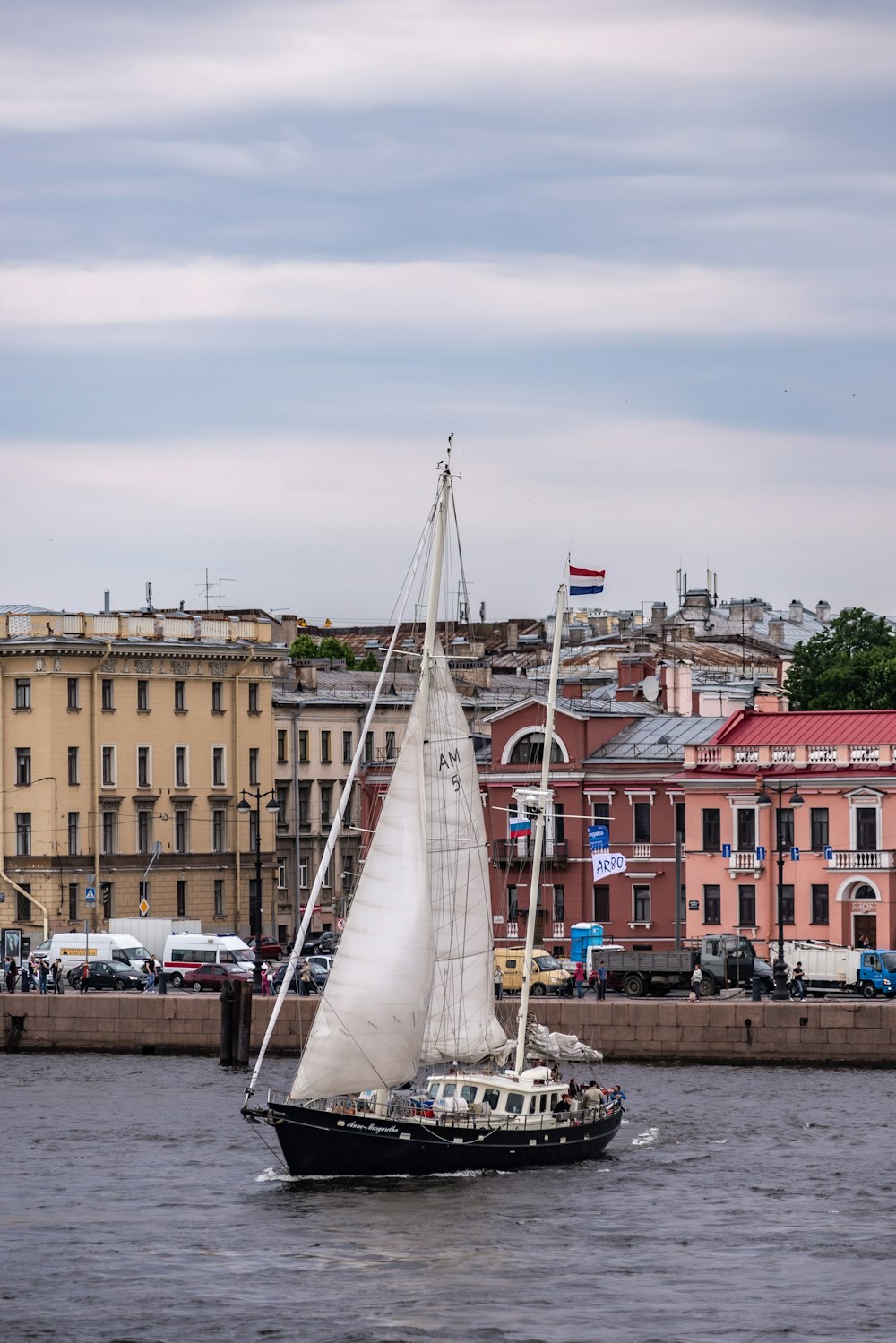 a sailboat in a body of water with buildings in the background