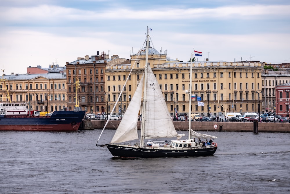 un velero en un cuerpo de agua frente a un gran edificio