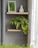 A warm, inviting photo of a minimalist wooden shelf with small plants and cozy decor in natural light.
