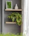 A warm, inviting photo of a minimalist wooden shelf with small plants and cozy decor in natural light.