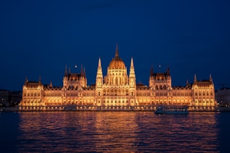a large building lit up at night on the water