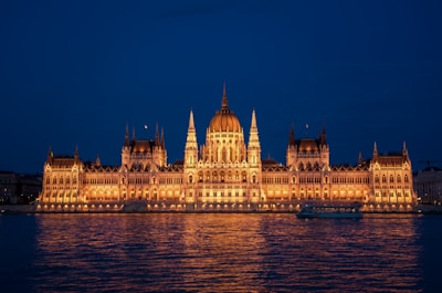 a large building lit up at night on the water