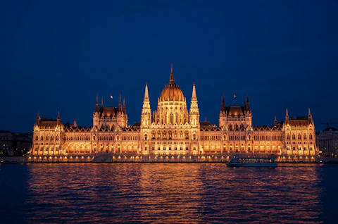 a large building lit up at night on the water