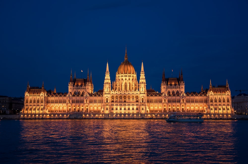 a large building lit up at night on the water