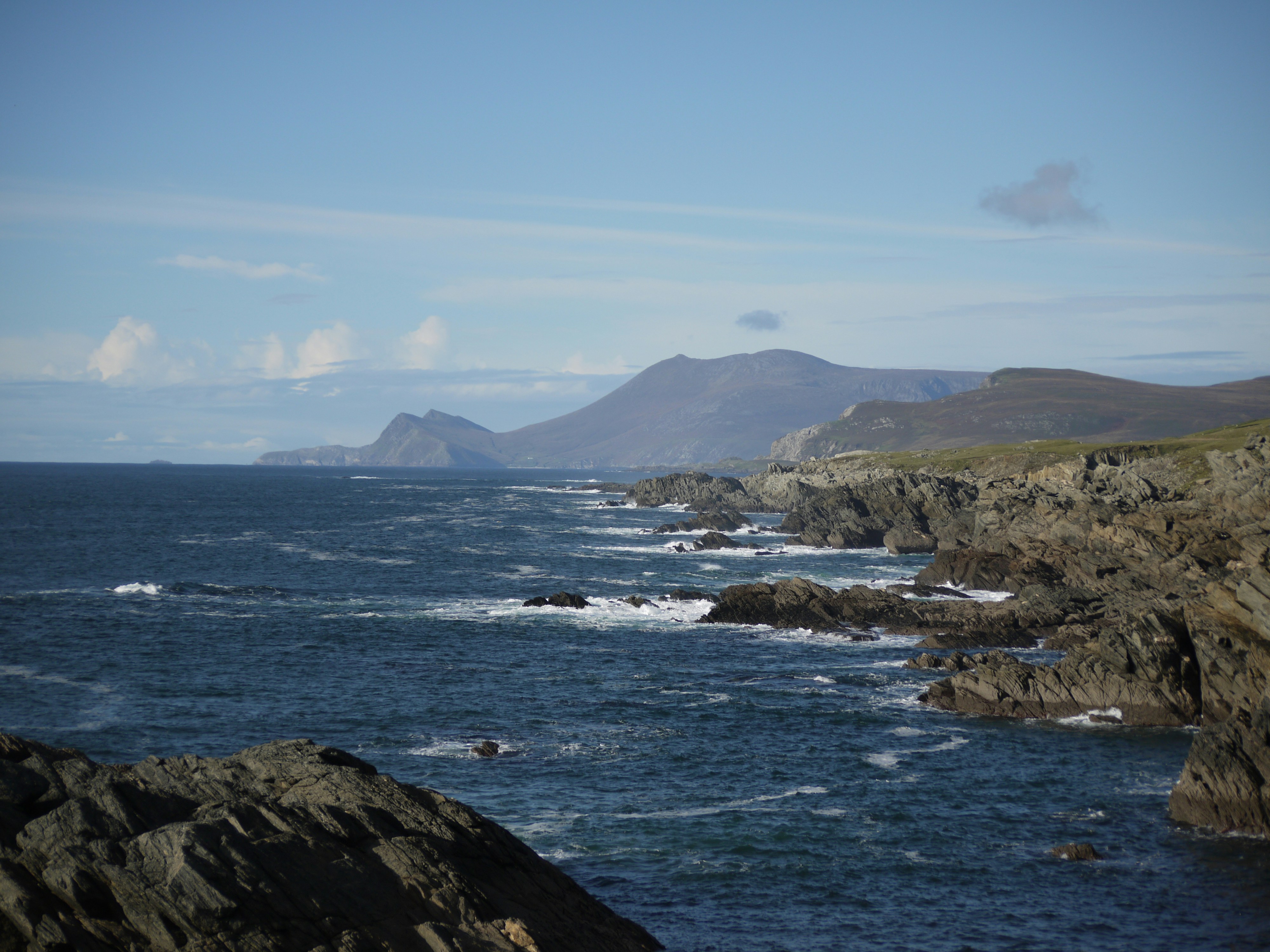 a view of the ocean with mountains in the background, 