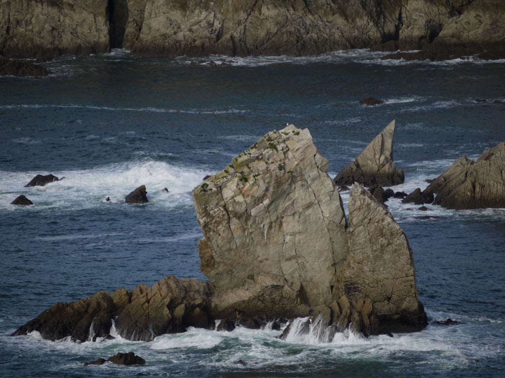 a large rock sticking out of the ocean