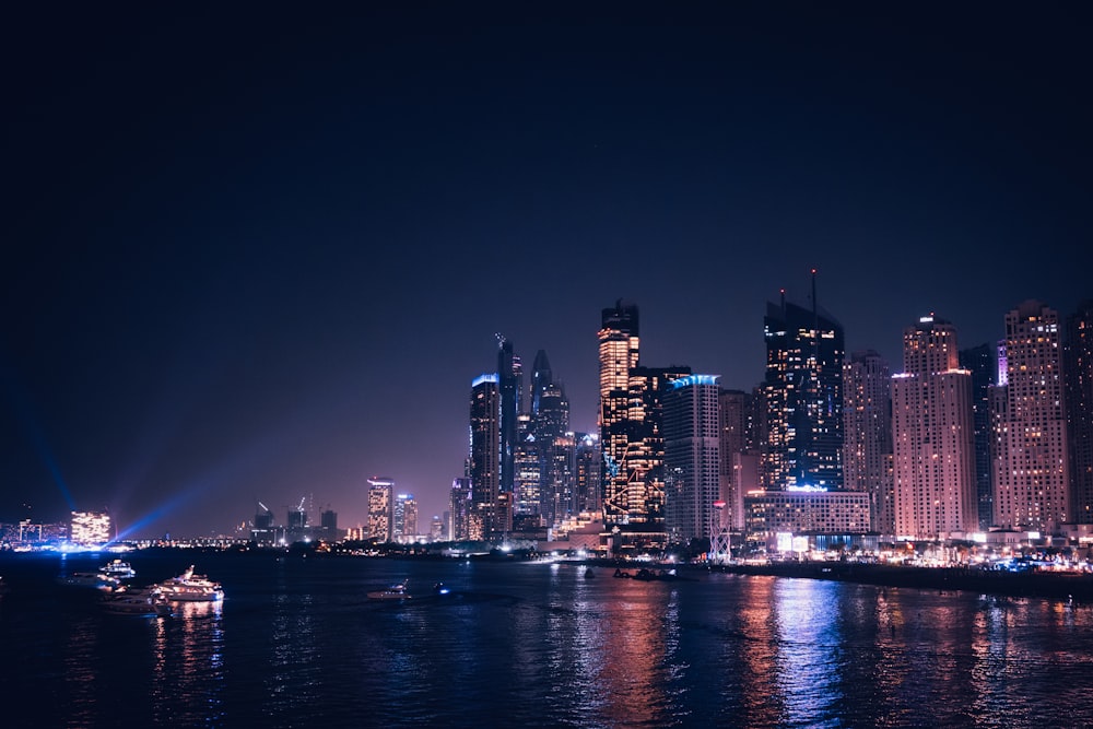 a city at night with a boat in the water