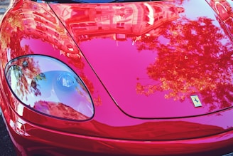Close-up of a shiny, freshly polished red sports car under Ontario sunlight.