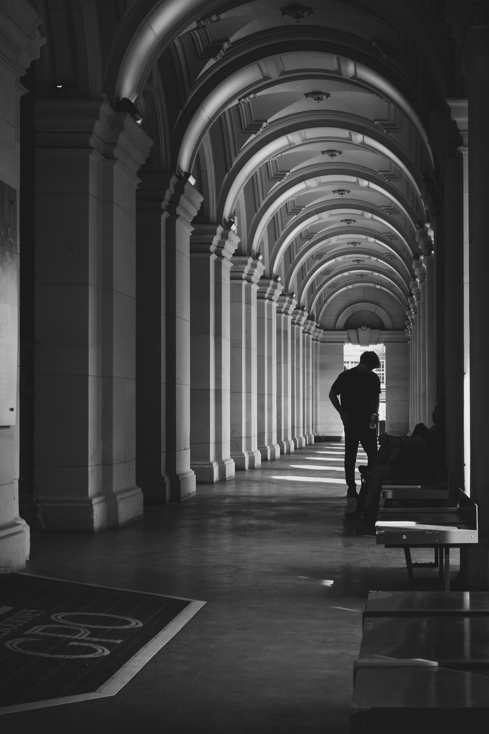 a man is standing in a long hallway