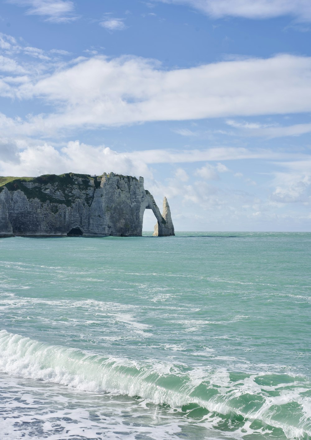 ein großer Felsen, der aus dem Meer ragt