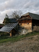 Close-up of solar panels catching the morning sun with a rustic barn in the background.