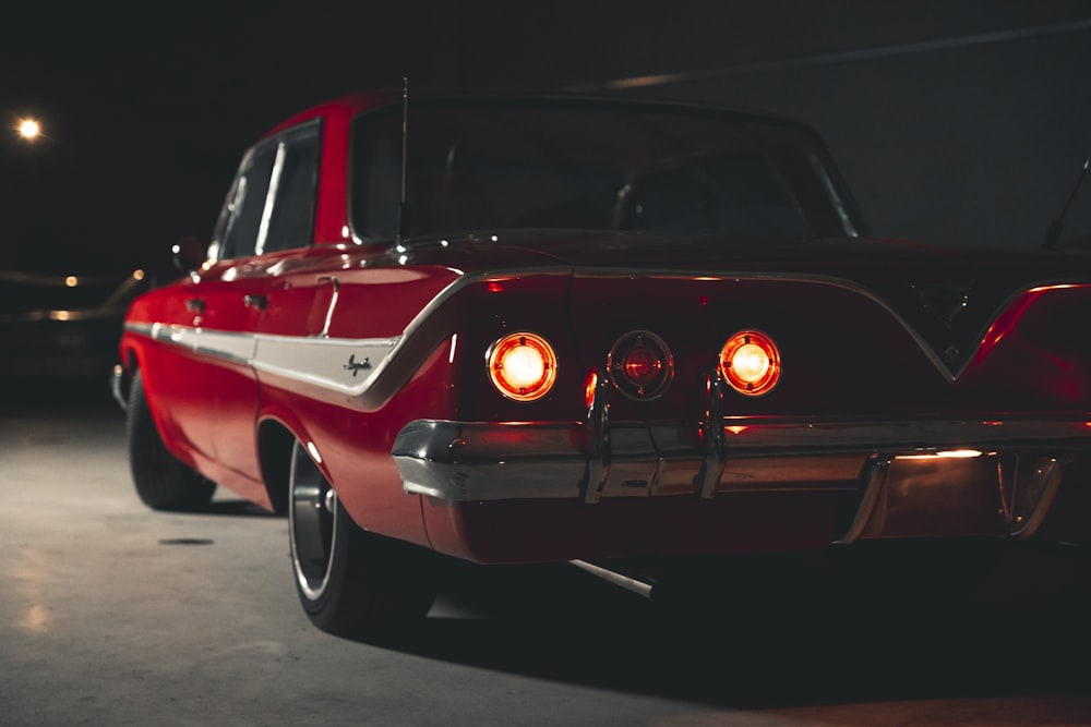 a red classic car parked in a garage